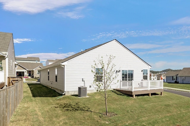 back of house featuring a yard, a wooden deck, and central air condition unit