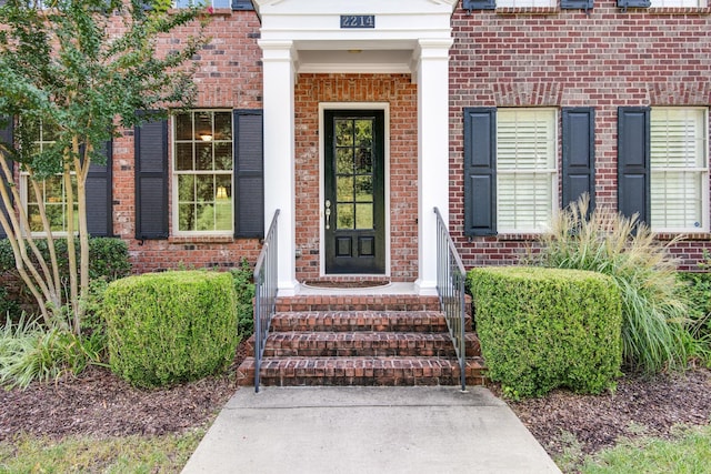 view of exterior entry featuring brick siding