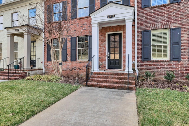 view of exterior entry featuring brick siding