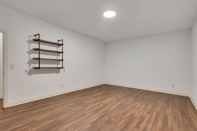 spare room featuring baseboards and wood finished floors