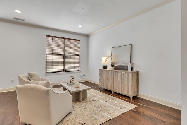 sitting room with ornamental molding, visible vents, dark wood finished floors, and baseboards