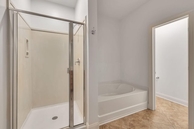 full bath with a garden tub, a shower stall, and baseboards