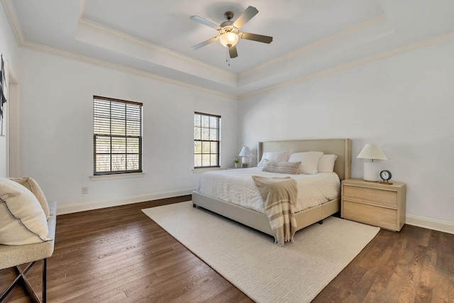 bedroom featuring dark wood-style flooring, a raised ceiling, and baseboards