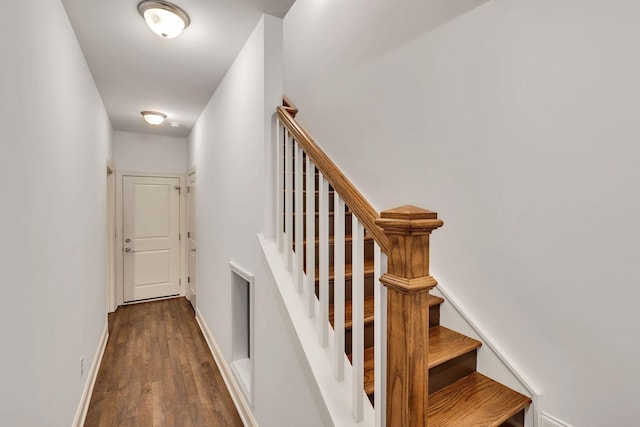 staircase with baseboards and wood finished floors