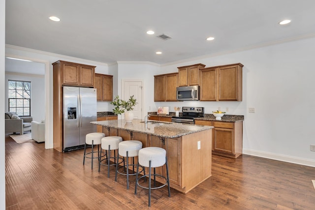 kitchen with dark wood finished floors, visible vents, stainless steel appliances, and a sink