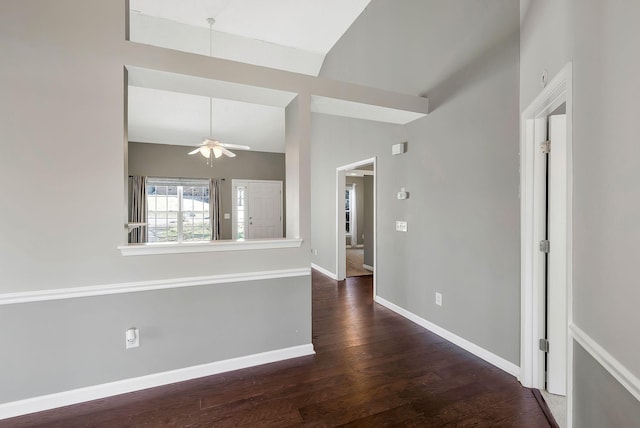 unfurnished room featuring lofted ceiling, ceiling fan, dark wood finished floors, and baseboards