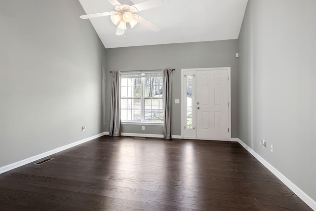 foyer entrance with ceiling fan, dark wood-type flooring, visible vents, baseboards, and vaulted ceiling