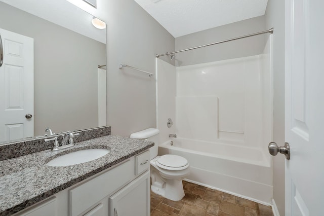 bathroom featuring bathtub / shower combination, stone finish flooring, vanity, and toilet