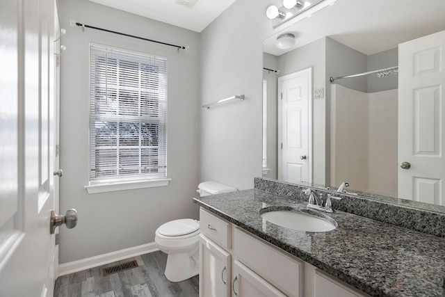 bathroom featuring toilet, a wealth of natural light, visible vents, and baseboards