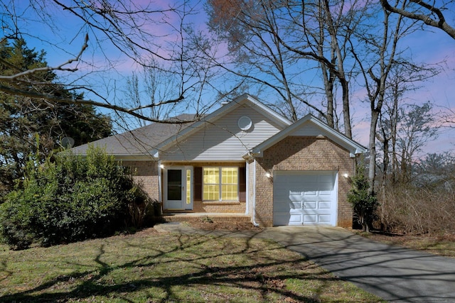 view of front of property featuring a garage, driveway, and brick siding