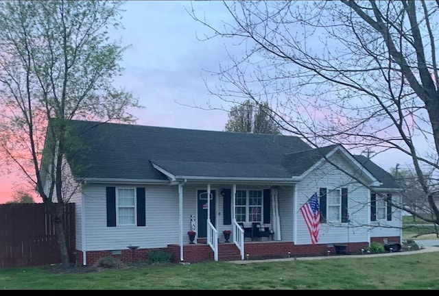 view of front of home featuring crawl space, covered porch, and a lawn