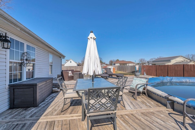 deck with outdoor dining space and a fenced backyard