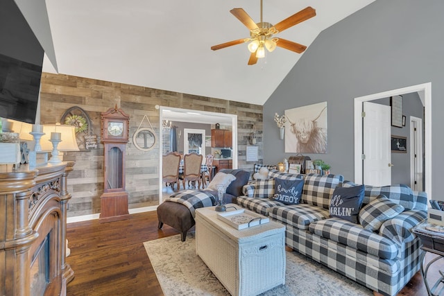 living area with baseboards, ceiling fan, high vaulted ceiling, and wood finished floors