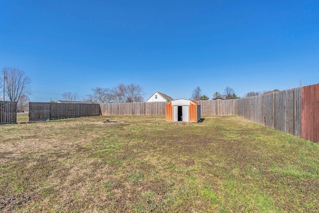 view of yard with an outbuilding, a storage shed, and a fenced backyard