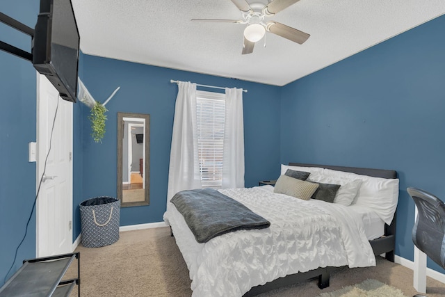 carpeted bedroom with a textured ceiling, ceiling fan, and baseboards