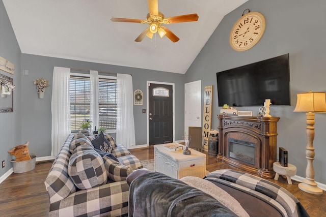 living room with vaulted ceiling, dark wood-style flooring, and a glass covered fireplace