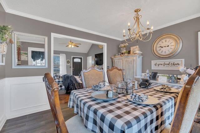 dining area featuring lofted ceiling, ornamental molding, wainscoting, wood finished floors, and ceiling fan with notable chandelier