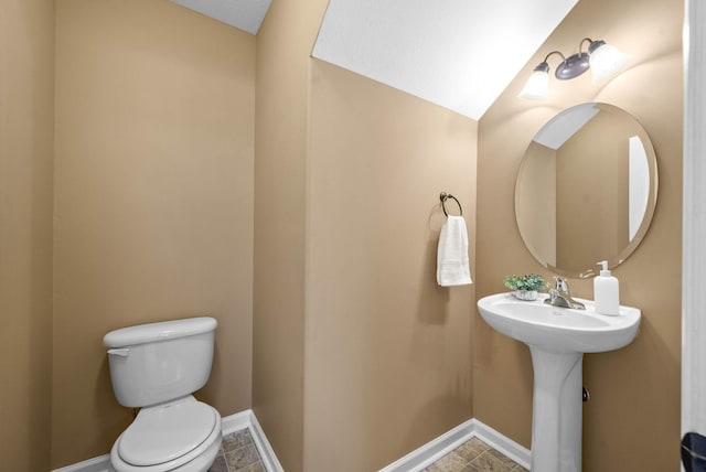 bathroom with toilet and baseboards