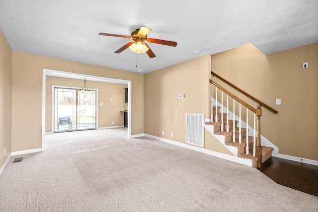 unfurnished room with visible vents, ceiling fan, baseboards, and stairs