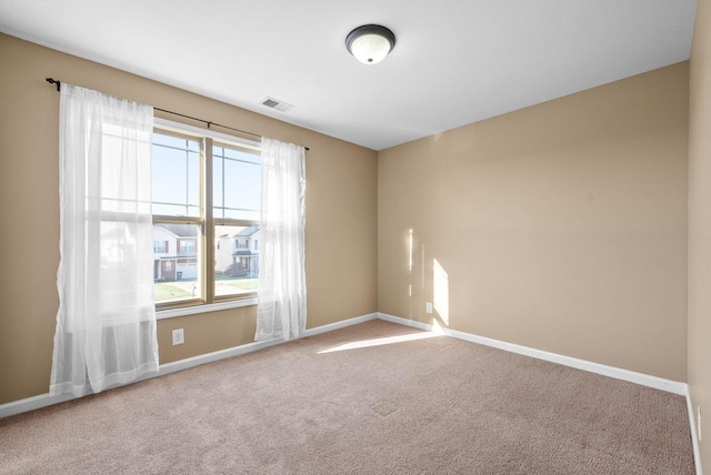 carpeted empty room with visible vents and baseboards