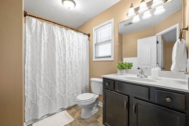 bathroom featuring toilet, vanity, visible vents, baseboards, and a shower with curtain