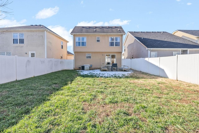 rear view of house featuring a fenced backyard, a lawn, and a patio