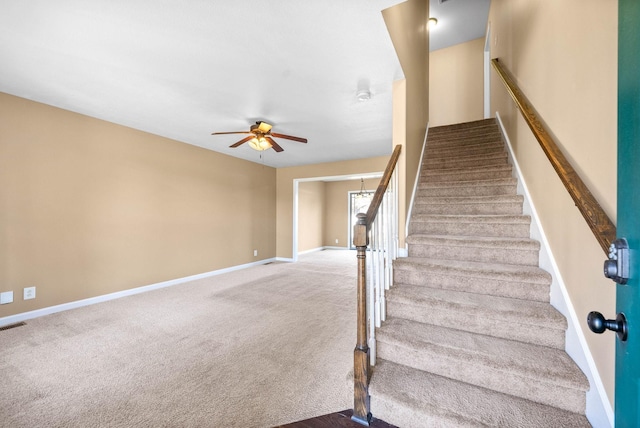 staircase featuring carpet, a ceiling fan, and baseboards