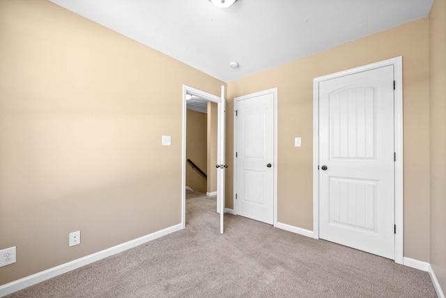 unfurnished bedroom with carpet floors and baseboards