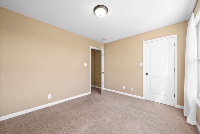 empty room featuring carpet floors and baseboards