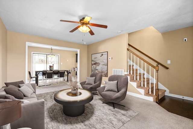 living area with dark wood-style floors, visible vents, stairway, a ceiling fan, and baseboards