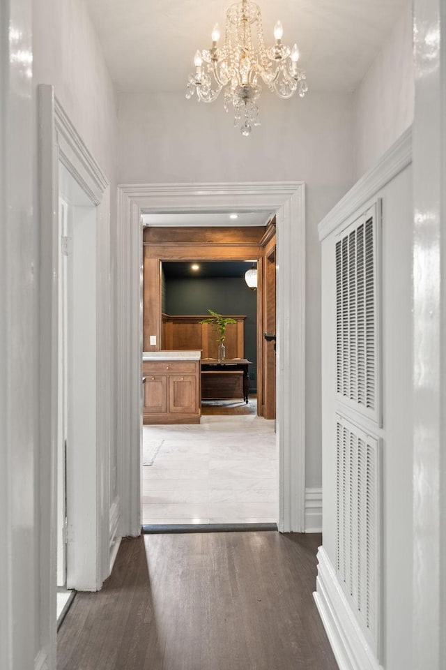 hallway featuring a chandelier, visible vents, and wood finished floors