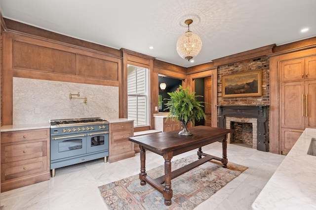 kitchen with brown cabinets, marble finish floor, a fireplace, and range with two ovens