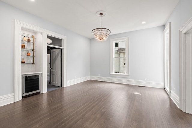 unfurnished living room featuring a dry bar, baseboards, wine cooler, dark wood-style flooring, and recessed lighting