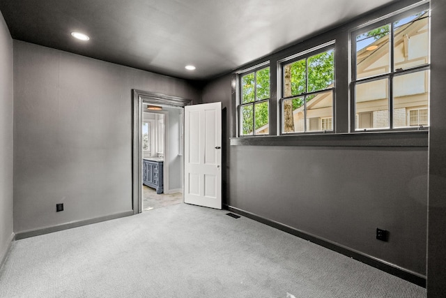 carpeted spare room featuring recessed lighting, visible vents, and baseboards