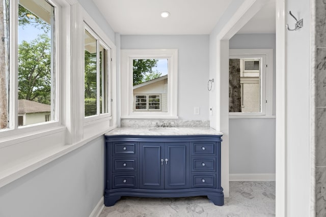 bathroom featuring marble finish floor, vanity, and baseboards