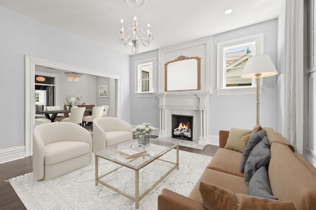 living area featuring baseboards, dark wood finished floors, a fireplace, a chandelier, and recessed lighting