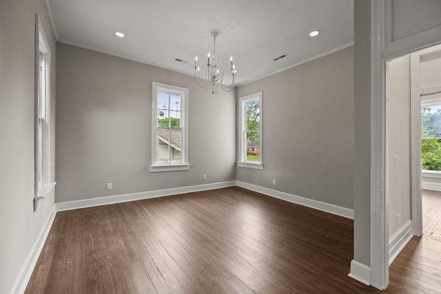 empty room featuring dark wood-style flooring, visible vents, crown molding, and baseboards