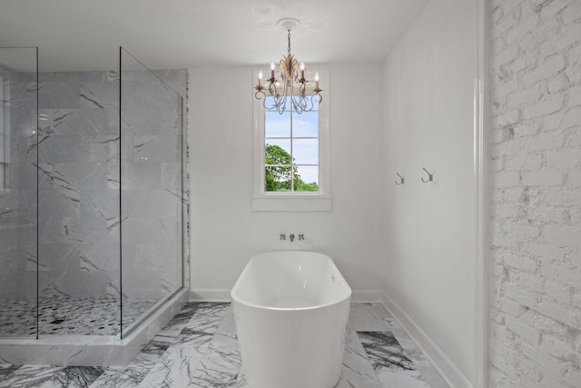 full bathroom featuring marble finish floor, a marble finish shower, a freestanding bath, a chandelier, and baseboards