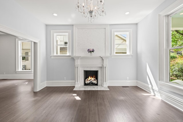 unfurnished living room with dark wood-style floors, recessed lighting, a high end fireplace, and baseboards