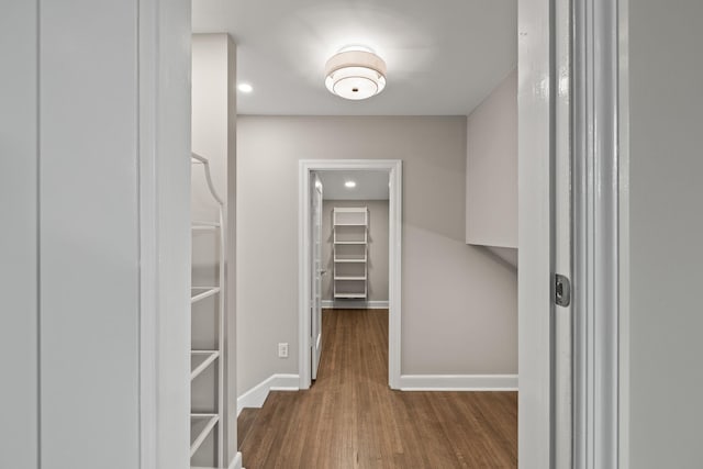 hall with baseboards and wood finished floors
