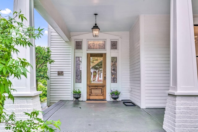 view of exterior entry featuring covered porch