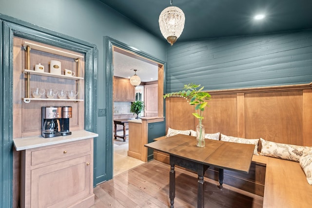 dining space with light wood-type flooring and a notable chandelier