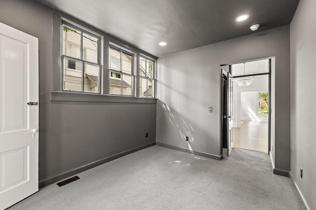 carpeted empty room with recessed lighting, visible vents, and baseboards