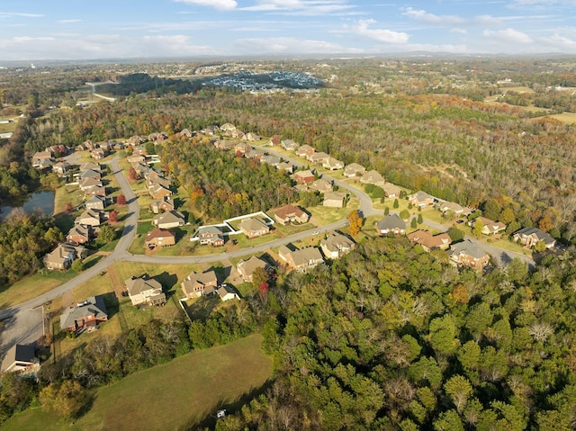 drone / aerial view featuring a residential view and a view of trees