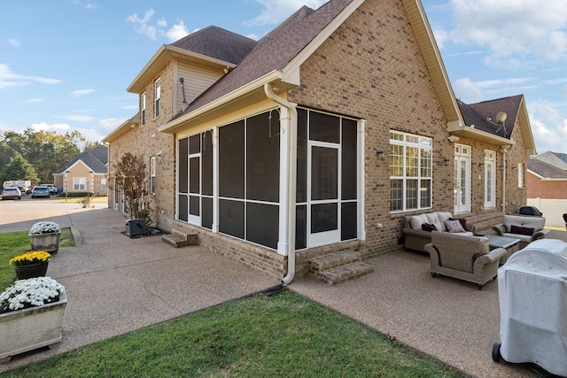 view of property exterior with a patio area, outdoor lounge area, a sunroom, and brick siding