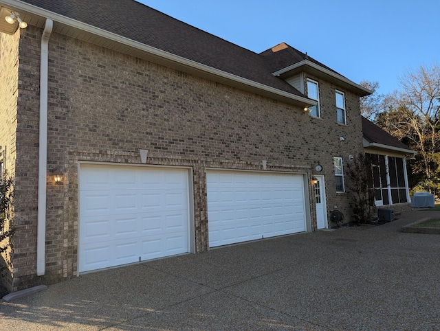 view of property exterior with driveway, roof with shingles, and brick siding