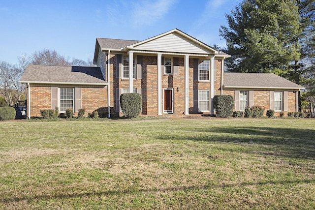 greek revival house with brick siding, a front lawn, and roof with shingles