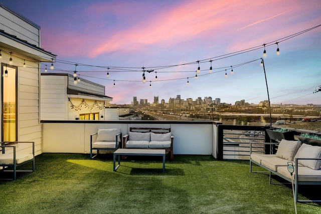 yard at dusk featuring a balcony, a view of city, and an outdoor hangout area