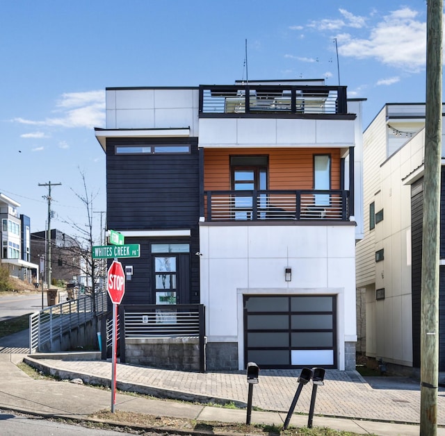 contemporary home with a garage and a balcony