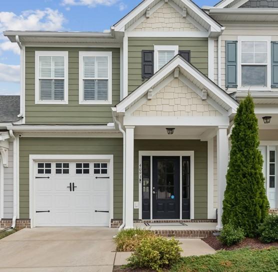 doorway to property featuring a garage, covered porch, and concrete driveway